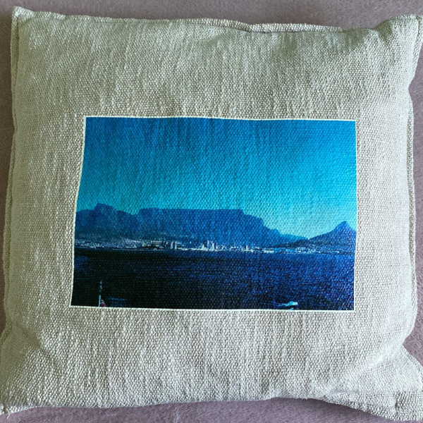 Photo of a cushion representing a seaside and mountain landscape